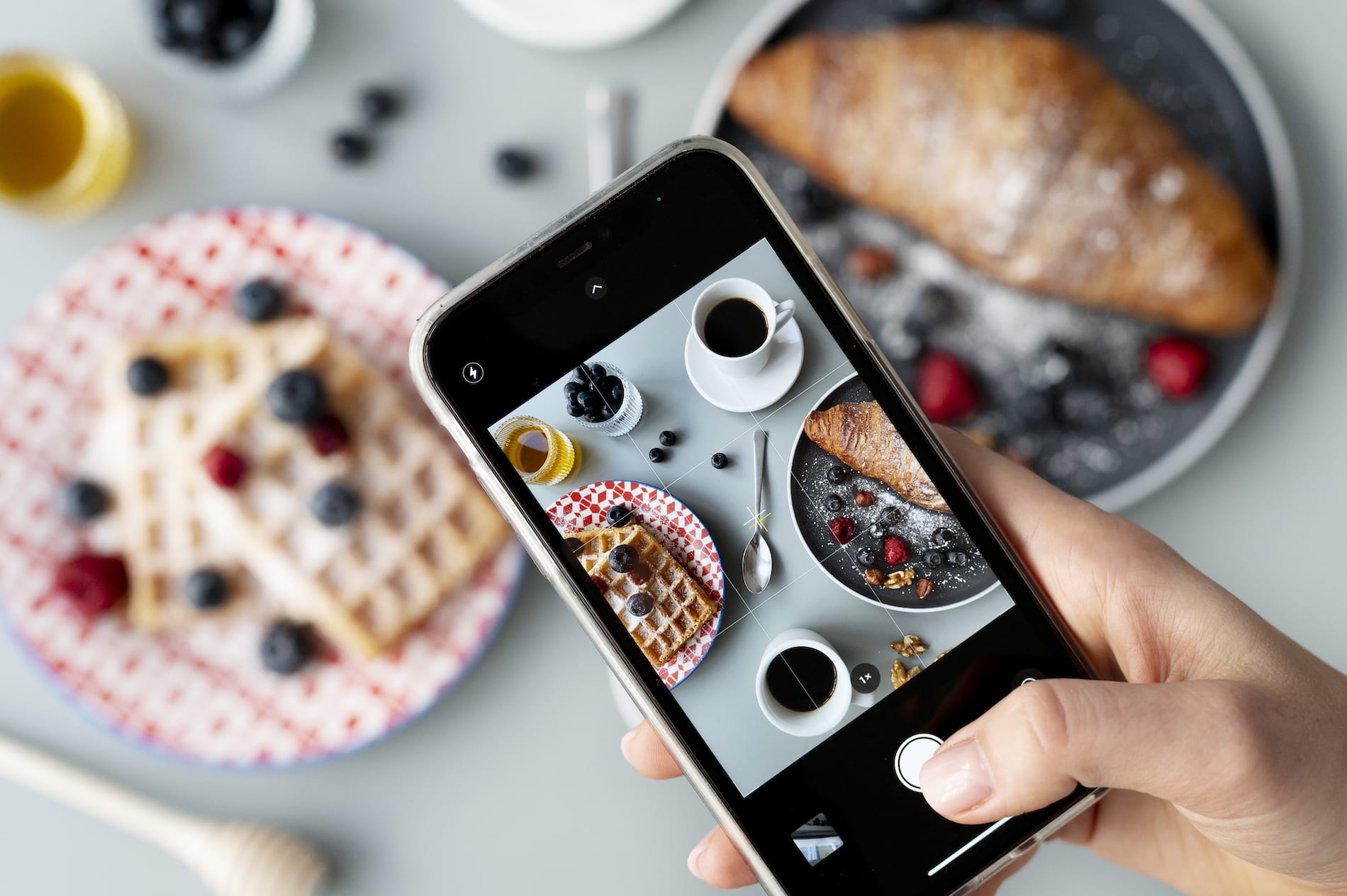 Cover image for SEO for food blogs – everything you need to know blog post. Image shows a user making food photos from waffles with an older iPhone.